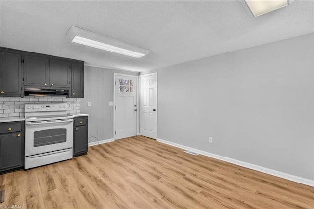 kitchen with under cabinet range hood, tasteful backsplash, white range with electric stovetop, light wood finished floors, and light countertops