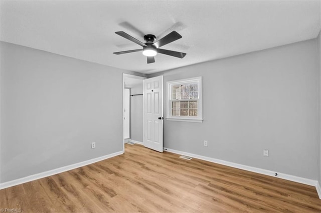 unfurnished bedroom with light wood-style flooring, a ceiling fan, and baseboards