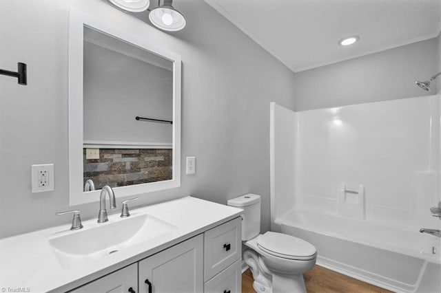 bathroom featuring toilet, vanity,  shower combination, and wood finished floors