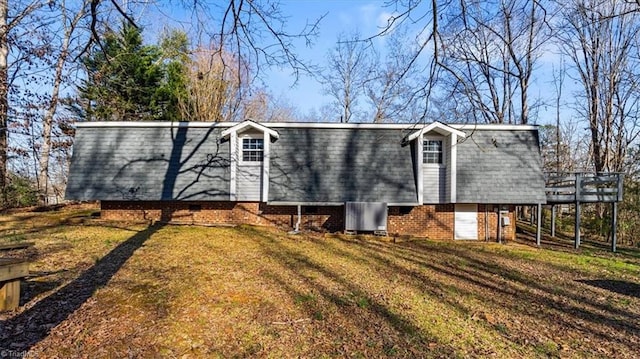 exterior space featuring a deck, mansard roof, cooling unit, a yard, and a shingled roof