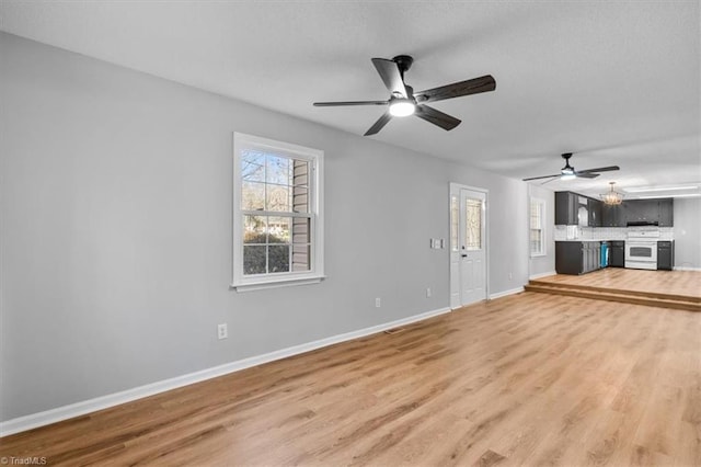 unfurnished living room with light wood-type flooring, baseboards, and ceiling fan