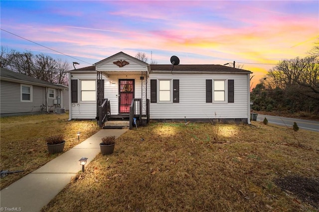 view of front of house featuring a yard and central air condition unit