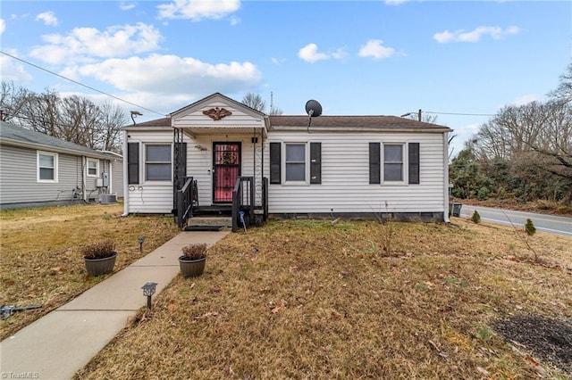 view of front of property with central AC and a front yard