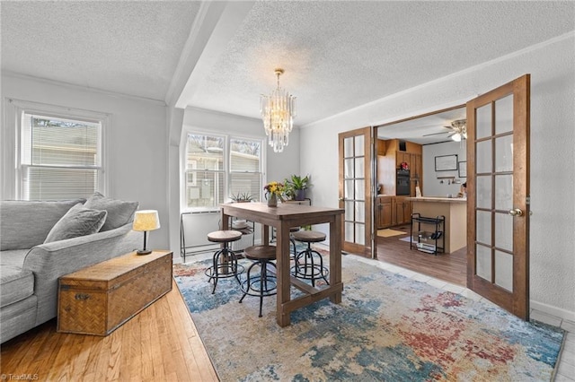 dining room featuring wood-type flooring, french doors, and a textured ceiling