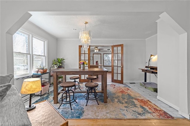 dining area featuring french doors, crown molding, and a notable chandelier