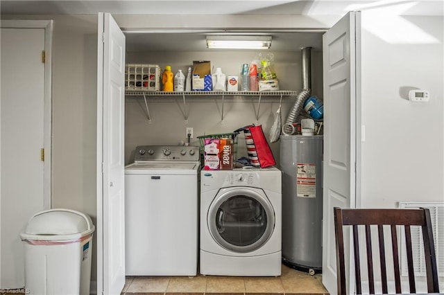 washroom featuring water heater, light tile patterned floors, and independent washer and dryer