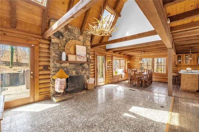 unfurnished living room featuring beam ceiling, high vaulted ceiling, and a chandelier