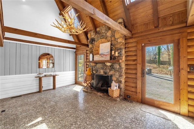 unfurnished living room with log walls, beam ceiling, high vaulted ceiling, and a fireplace