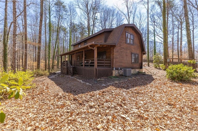 view of side of home with a gambrel roof, central AC, a porch, a shingled roof, and log exterior