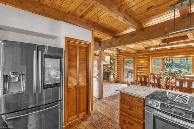 kitchen featuring beamed ceiling, wood ceiling, a stone fireplace, stainless steel appliances, and wood-type flooring