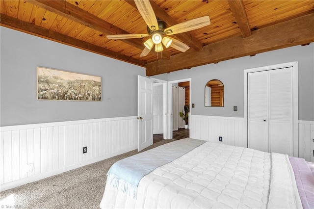 bedroom featuring beam ceiling, wainscoting, and wood ceiling