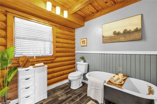 full bathroom with wood finish floors, toilet, a freestanding bath, wooden ceiling, and rustic walls