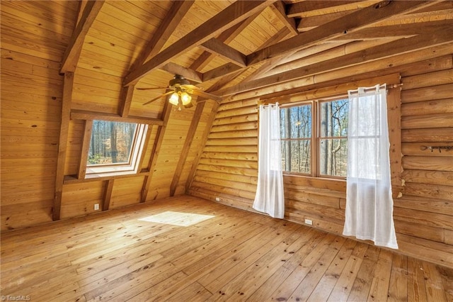 spare room featuring ceiling fan, wood ceiling, lofted ceiling with beams, hardwood / wood-style flooring, and log walls