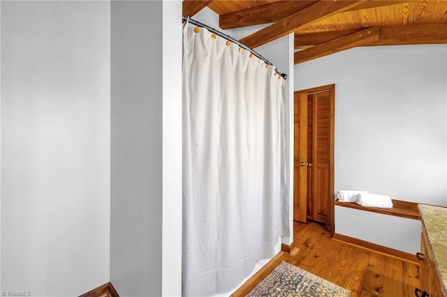 bathroom with vaulted ceiling with beams, wood ceiling, baseboards, and wood finished floors