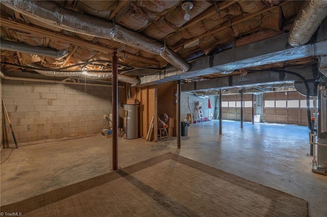 basement featuring concrete block wall and water heater