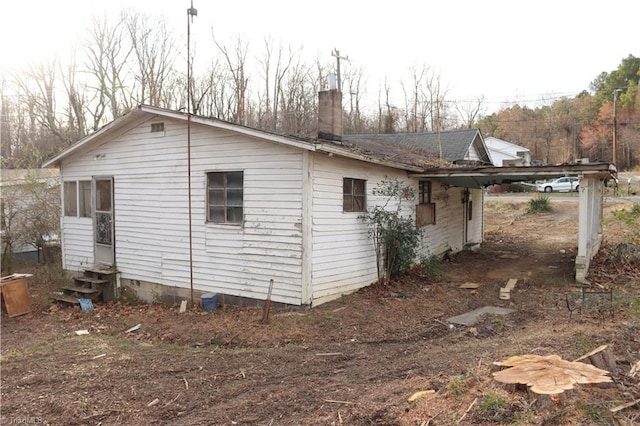 view of home's exterior with entry steps and a chimney