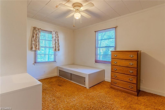 unfurnished bedroom with light carpet, ceiling fan, baseboards, and crown molding