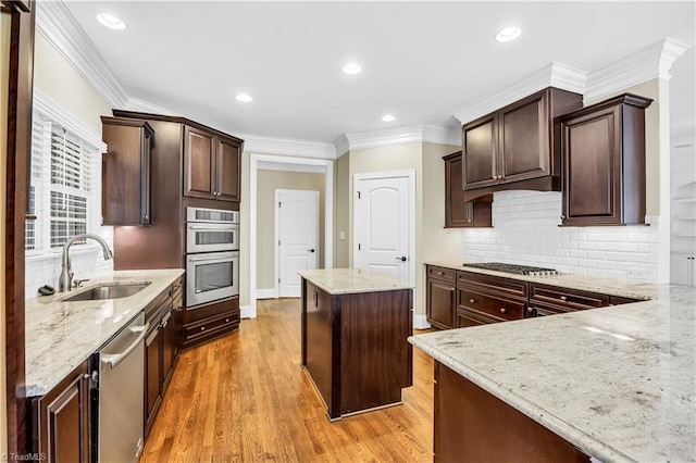 kitchen featuring a kitchen island, light stone counters, and light wood-type flooring