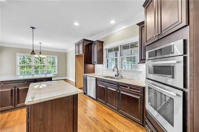 kitchen with a center island, stainless steel appliances, sink, and light hardwood / wood-style flooring