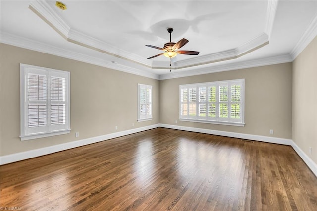 spare room featuring ceiling fan, a raised ceiling, wood-type flooring, and ornamental molding