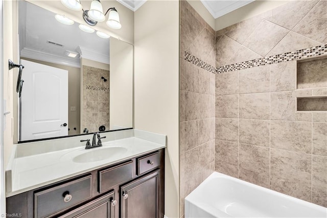 bathroom featuring vanity, ornamental molding, and tiled shower / bath combo