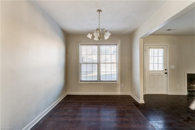 interior space featuring a chandelier, a textured ceiling, and dark hardwood / wood-style floors