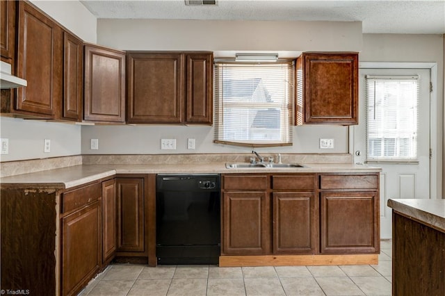 kitchen with sink, a textured ceiling, black dishwasher, and light tile patterned flooring