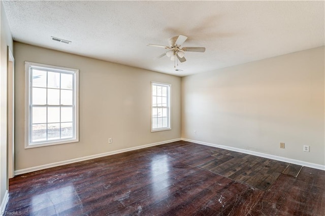 spare room with ceiling fan, dark wood-type flooring, and a textured ceiling