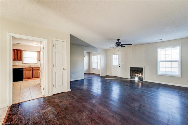 unfurnished living room featuring sink, a textured ceiling, ceiling fan, and dark hardwood / wood-style flooring