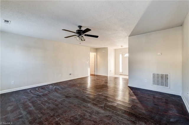 empty room featuring ceiling fan, a textured ceiling, and dark hardwood / wood-style floors