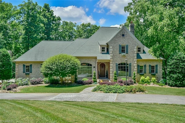 french country inspired facade with a front lawn