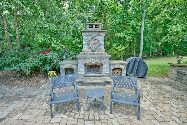 view of patio / terrace with grilling area and an outdoor stone fireplace