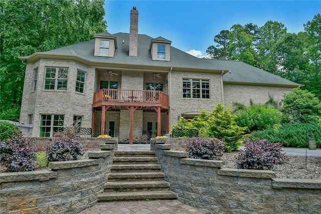 view of front of home featuring ceiling fan and a balcony