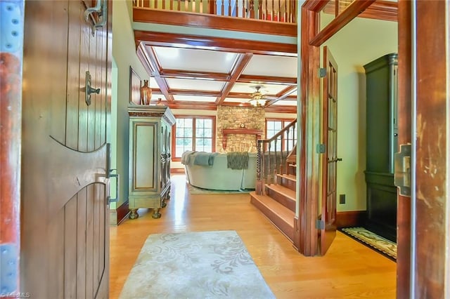 interior space featuring light hardwood / wood-style floors, coffered ceiling, and beamed ceiling