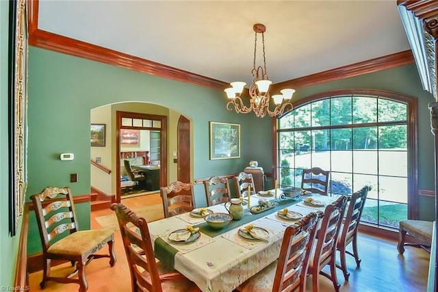 dining area featuring hardwood / wood-style floors, a chandelier, and crown molding