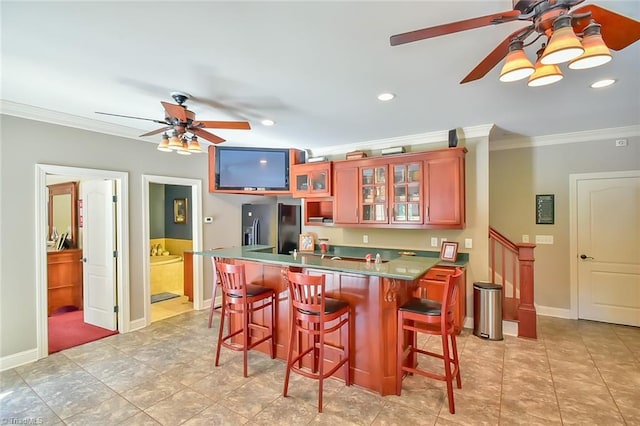 kitchen with ornamental molding, a kitchen breakfast bar, black refrigerator with ice dispenser, and ceiling fan