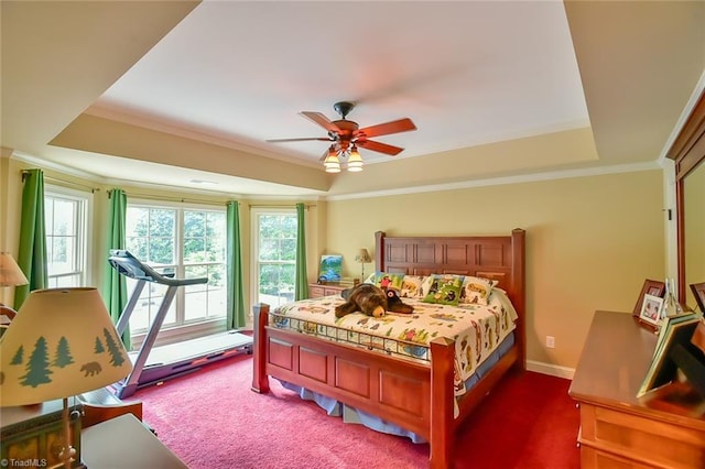 carpeted bedroom featuring ceiling fan, a tray ceiling, and ornamental molding