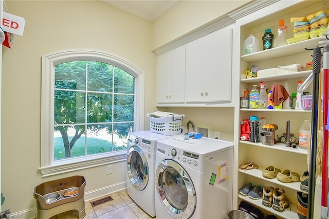 washroom with cabinets, separate washer and dryer, light tile patterned floors, and plenty of natural light