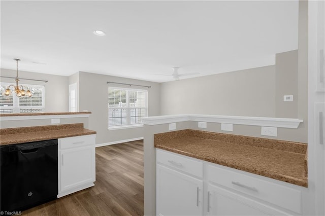 kitchen featuring dark wood-type flooring, hanging light fixtures, dishwasher, ceiling fan with notable chandelier, and white cabinets