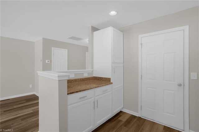 kitchen with white cabinetry, dark hardwood / wood-style flooring, and kitchen peninsula