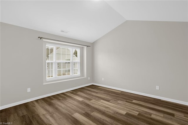 spare room with lofted ceiling and dark hardwood / wood-style flooring