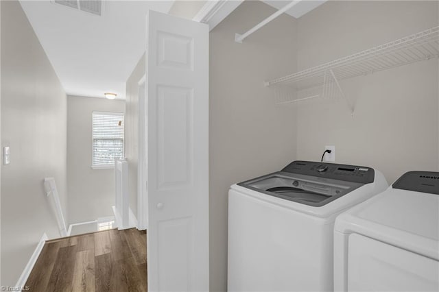 laundry area with separate washer and dryer and dark hardwood / wood-style floors