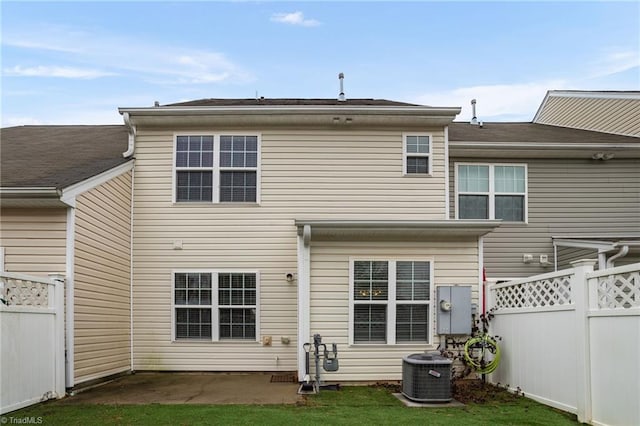 rear view of property featuring a yard, cooling unit, and a patio area