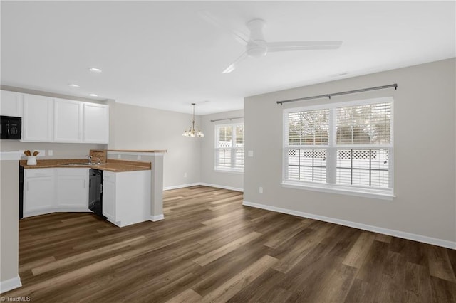 kitchen featuring ceiling fan with notable chandelier, white cabinets, dark hardwood / wood-style flooring, and decorative light fixtures