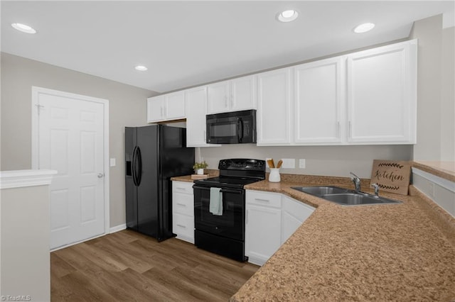 kitchen featuring hardwood / wood-style flooring, white cabinetry, sink, and black appliances