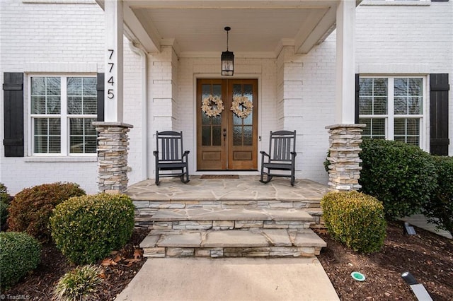 entrance to property with covered porch and french doors