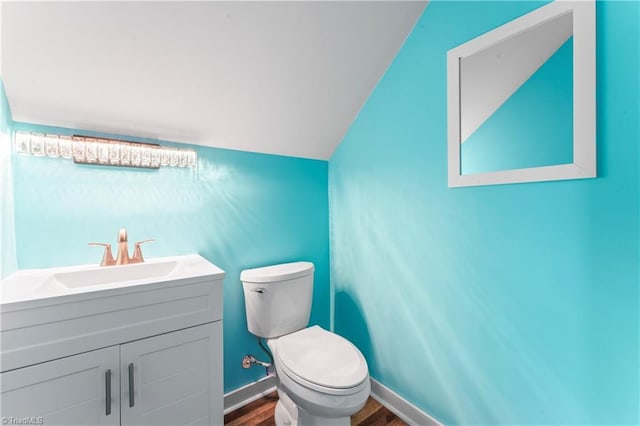 1420 Burnetts Chapel Rd, Greensboro, NC 27407 - half bath featuring wood finished floors, toilet, lofted ceiling, vanity, and baseboards