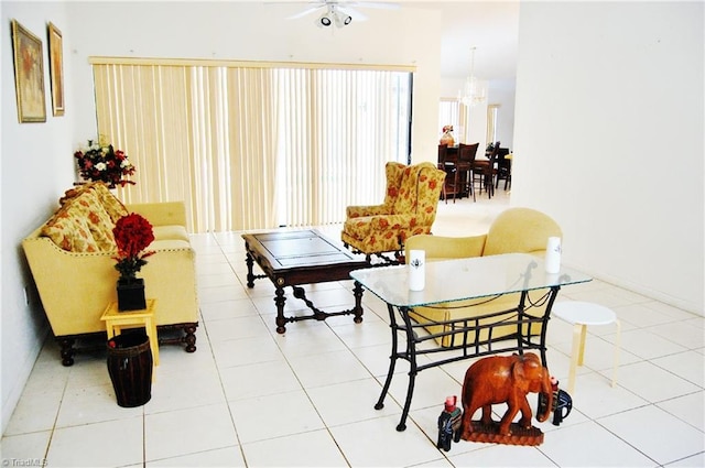 living room with light tile patterned floors and ceiling fan with notable chandelier