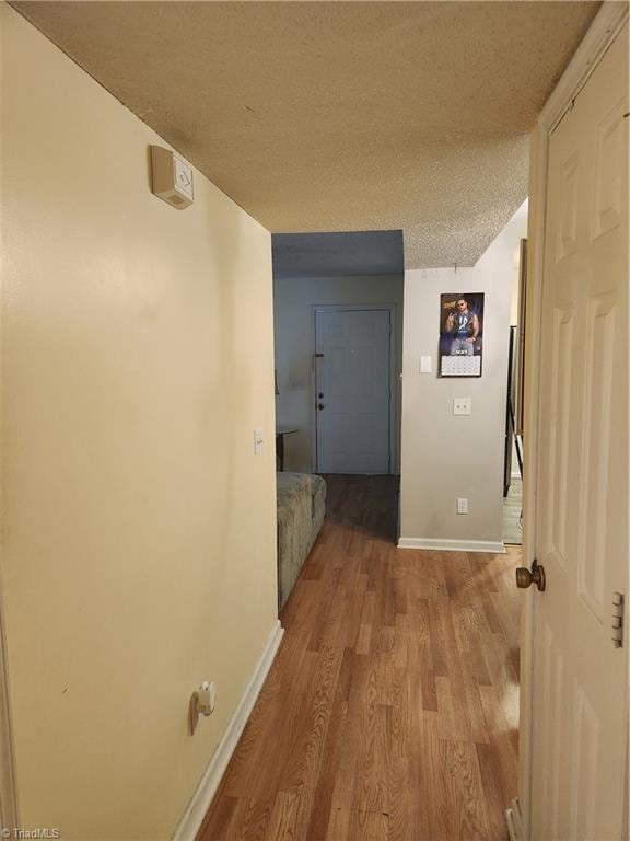 5517 Hornaday Rd Unit D, Greensboro, NC 27409 - hallway featuring wood finished floors, a textured ceiling, and baseboards
