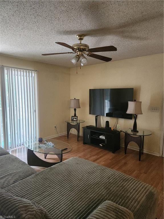 5517 Hornaday Rd Unit D, Greensboro, NC 27409 - living room featuring baseboards, a ceiling fan, wood finished floors, and a textured ceiling